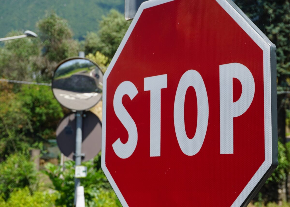 a red stop sign sitting next to a street light