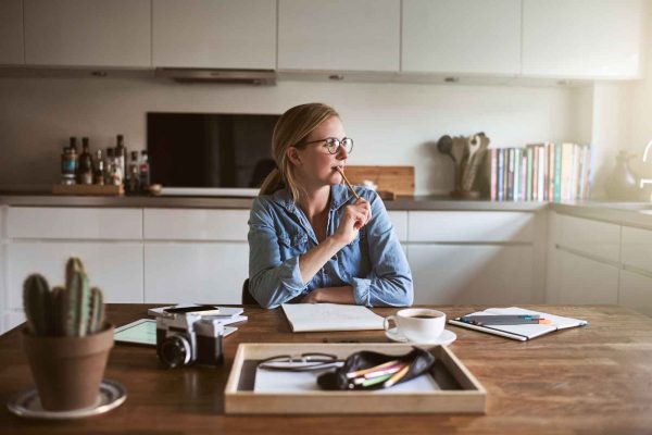 A thoughtful entrepreneur working at a desk, symbolizing the deep reflection of Highly Sensitive Persons in business.